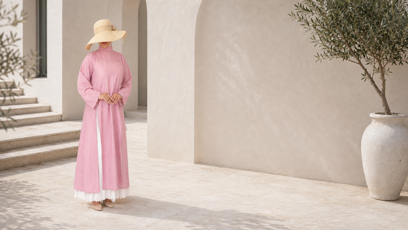 Liquette TAHARA 100% lin rose poudré, silhouette longue et modeste dans une cour méditerranéenne